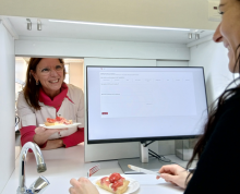 dégustateur dans une cabine, servi par un passe-plat avec un gâteau aux fraises